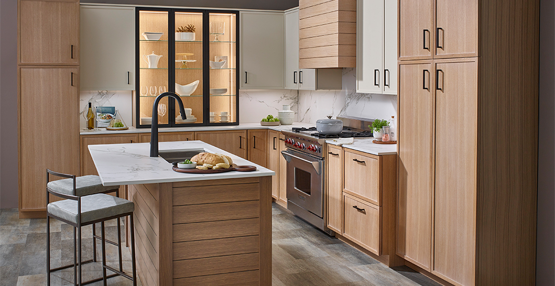 Tall wooden kitchen cabinets with black handles